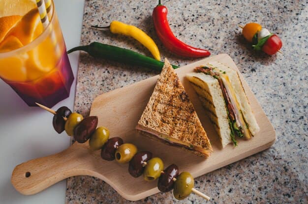 Sandwiches on a board with olives and drink