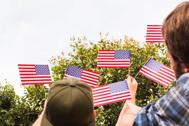 Rear view of two people holding small usa flags in their hands