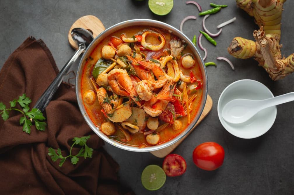 Spicy seafood soup with herbs and vegetables in a pot