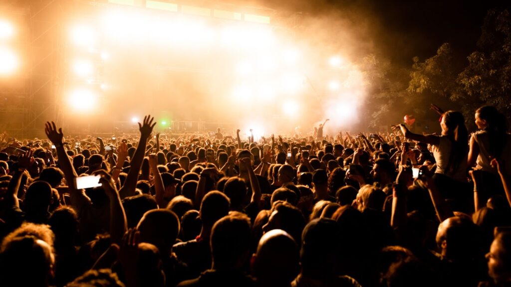 Large group of music fans in front of the stage during music concert