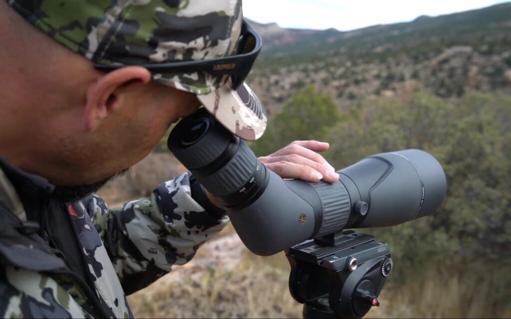 a man looking through the scope