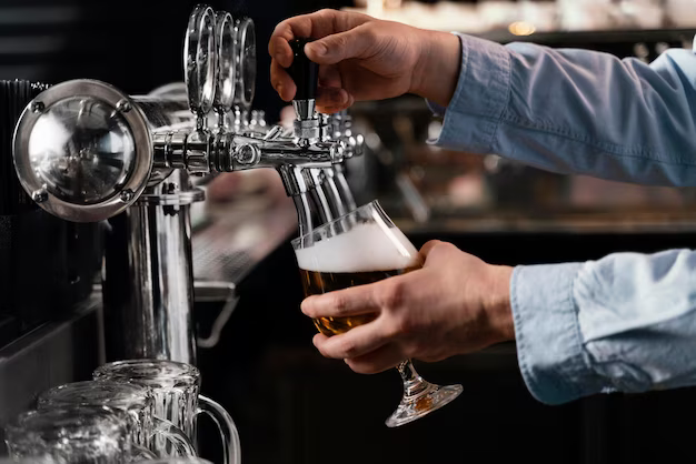 Hands pouring beer into a glass, close-up
