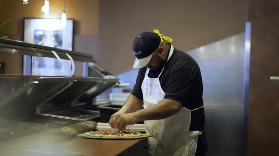 A person preparing pizza