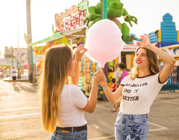 Two happy women holding cotton candy