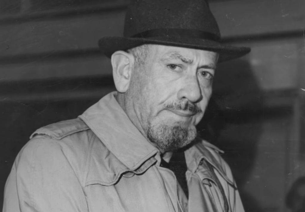 Elderly man in a hat with a stern expression