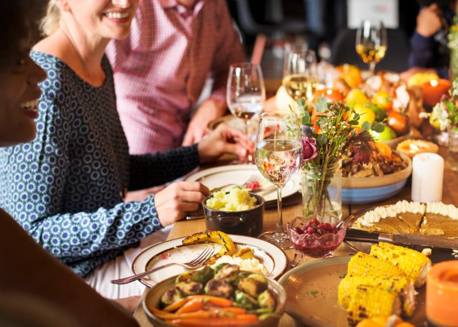 A joyful group enjoying a festive dinner with various dishes
