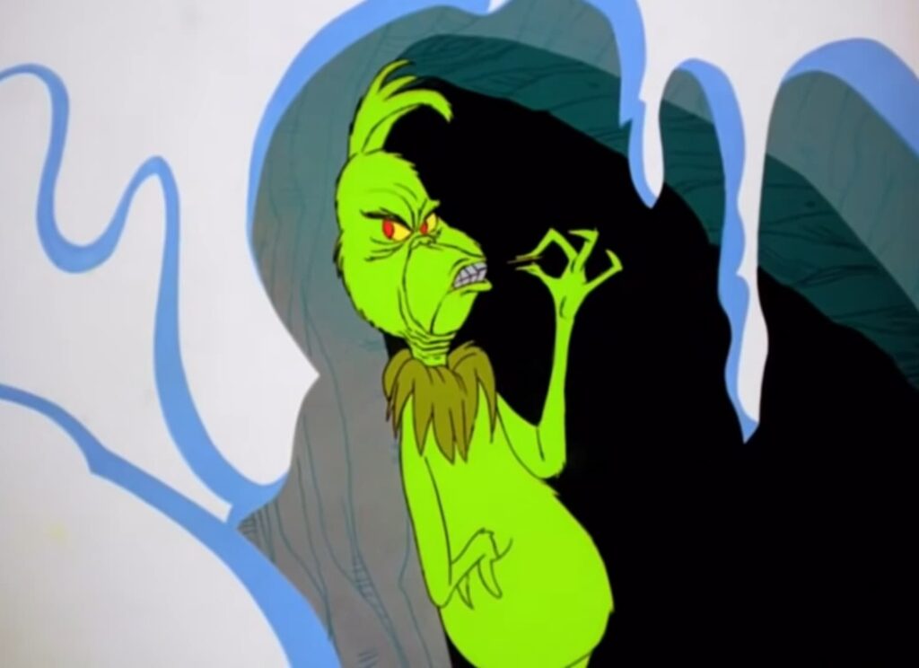 A green creature with a sneer and narrowed eyes