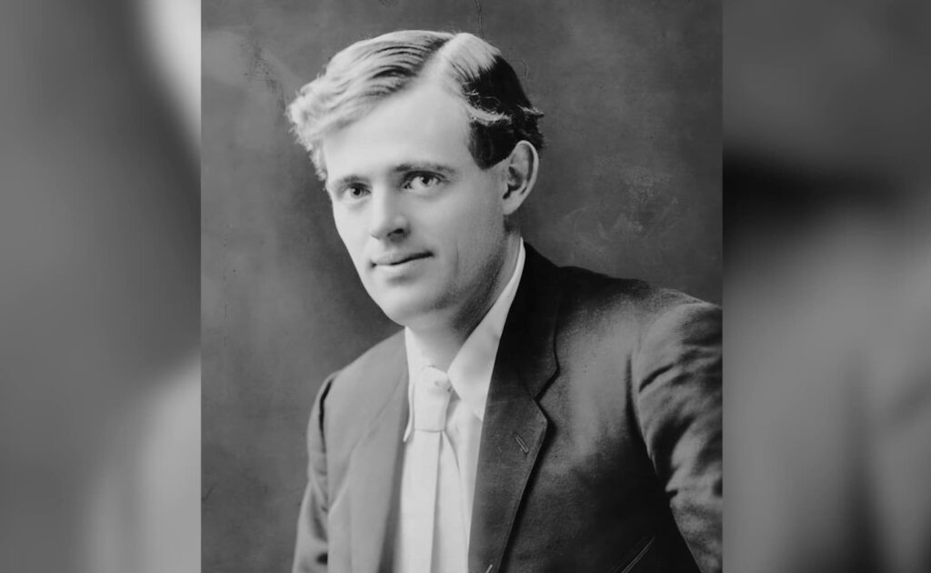 a black and white old photo of a young man with parted hair and a gentle smile